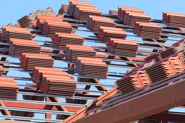 Roof under construction with stacks of roof tiles for home build — Stock Photo, Image