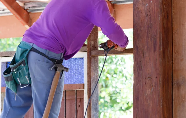 Carpenter drill wood for house construction — Stock Image Carpenter drill wood for house construction Stock Picture