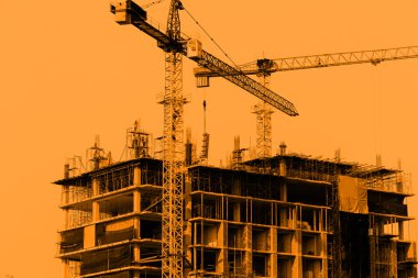 Mavi gökyüzü arka planında vinçleri olan inşaat alanı
