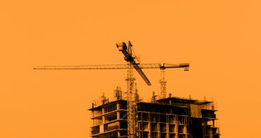 Mavi gökyüzü arka planında vinçleri olan inşaat alanı