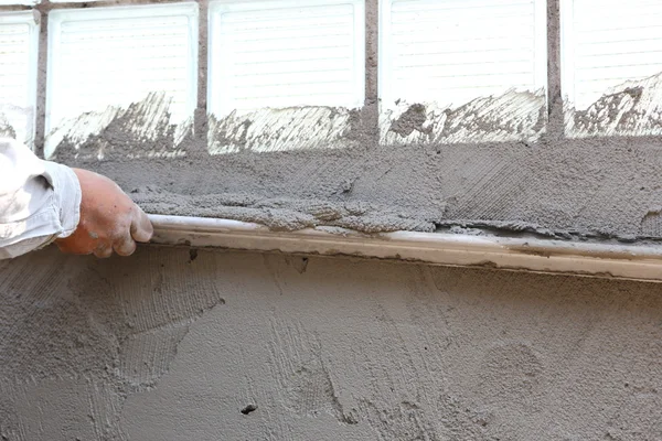 Estucador de concreto trabalhador na parede da construção da casa — Fotografia de Stock