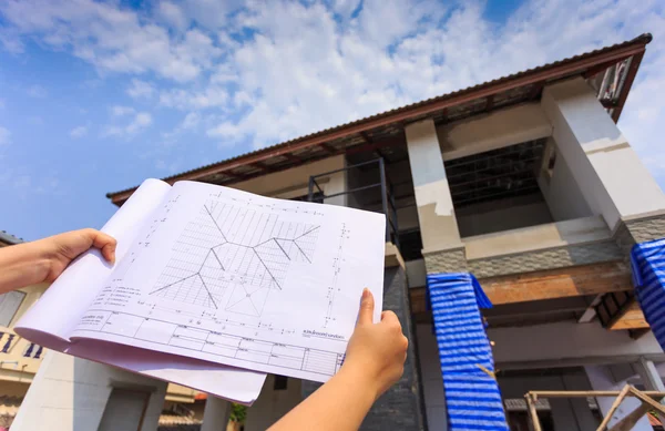 Architecture drawings in hand on big house building — Stock Photo, Image