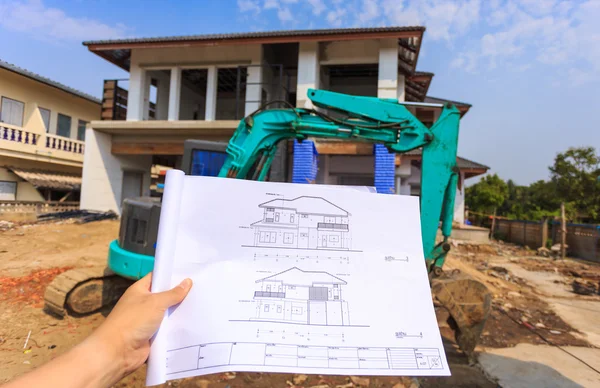 Architecture drawings in hand on big house building — Stock Photo, Image