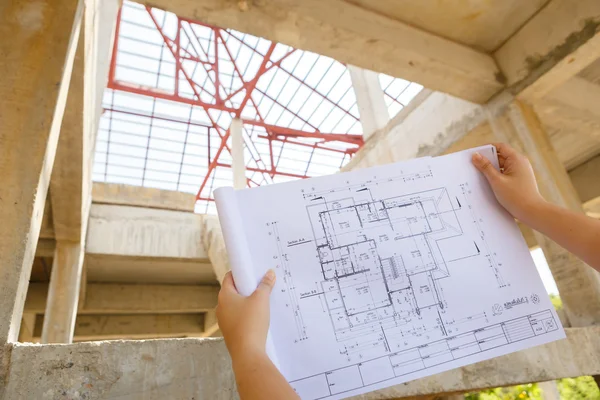 Architecture drawings in hand on house building background — Stock Photo, Image