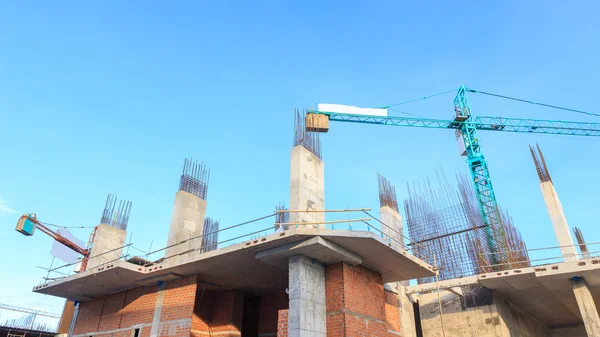 Guindaste de construção e canteiro de obras sob céu azul — Fotografia de Stock