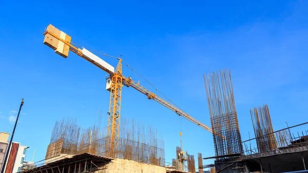 Stavební jeřáb a stavební místo pod modrou oblohou — Stock fotografie