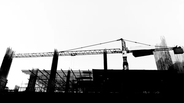 Site de construction avec grues sur fond de silhouette — Photo