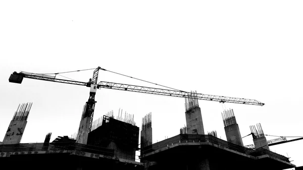 Будівельний майданчик з кранами на фоні силуету — стокове фото