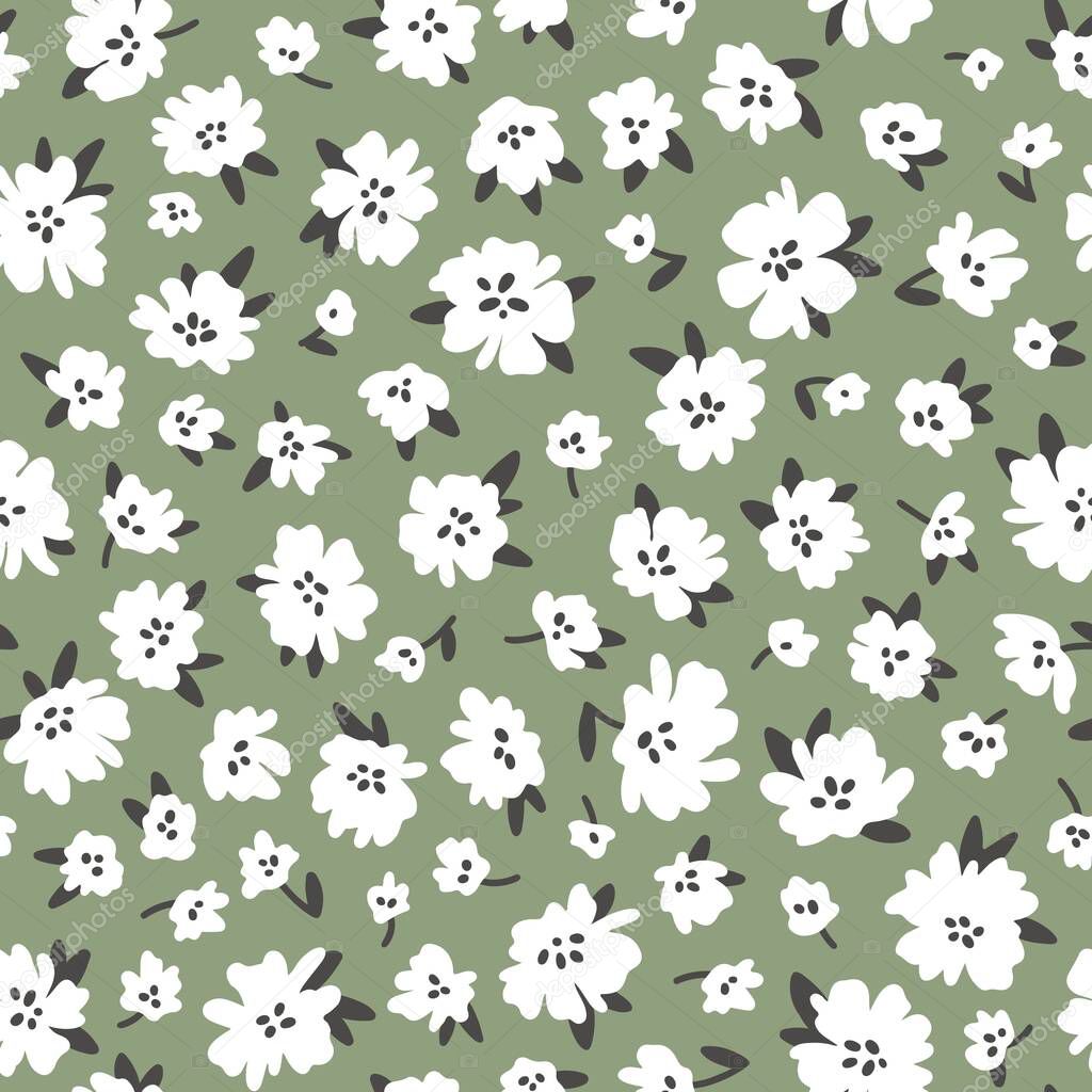 Calico millefleurs seamless pattern. Small white summer wildflowers in a simple hand drawn cartoon style on a green background. Ideal for textile, fabric, surface, wallpaper, scrapbooking, wrapping.