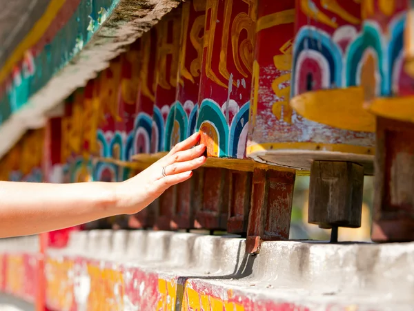 Vrouwelijke hand spinnen de wielen gebed voor goede karma — Stockfoto