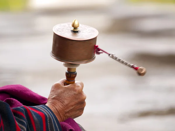 Una donna anziana che gira la ruota della preghiera — Foto Stock