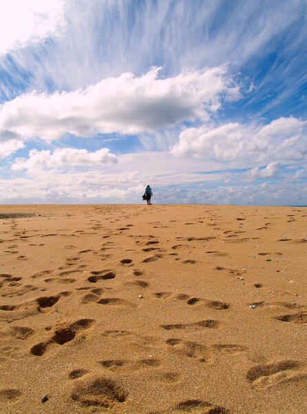 Girl walking on the beach to infinity