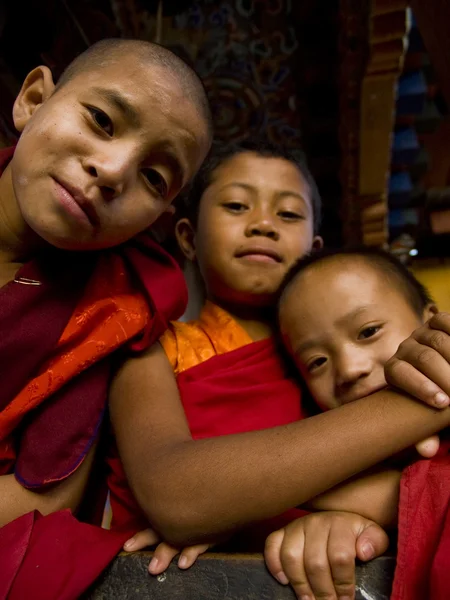 Unga buddhistiska munkar poserar framför gudomliga galning fertilitet templet Chimi Lhakhang — Stockfoto