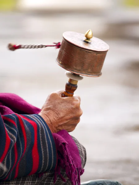 Eine ältere Frau, die ihre Gebetsmühle dreht — Stockfoto