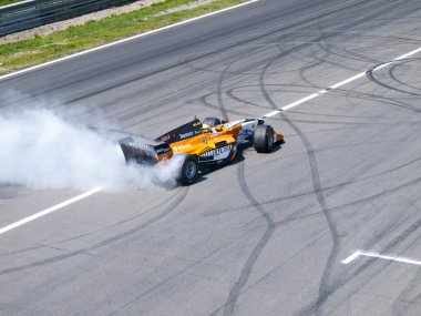 Tom coronel bazı lastik bir formula arabanın içinde yanıyor.