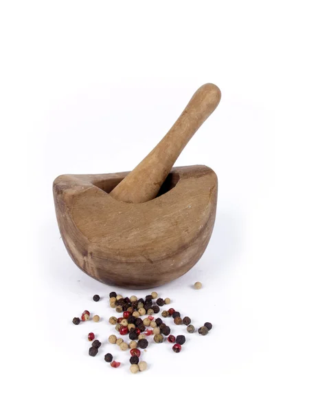 Wooden mortar and pestle with peppercorn over a white background Royalty Free Stock Photos