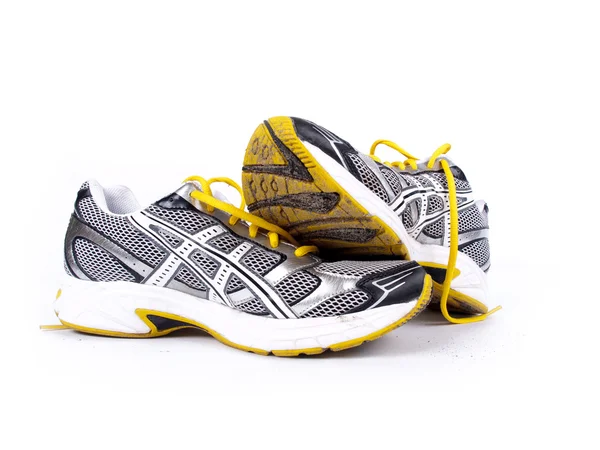 Used dirty pair of running shoes over a white background — Stock Photo, Image