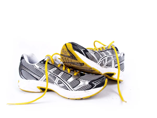 Used dirty pair of running shoes over a white background — Stock Photo, Image