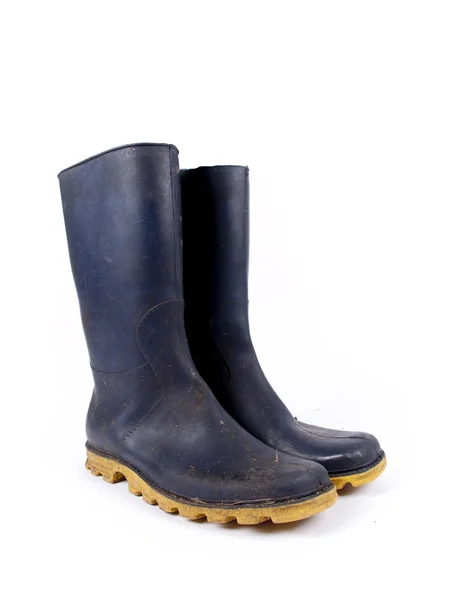 Par de botas de borracha suja azul escuro sobre um fundo branco — Fotografia de Stock