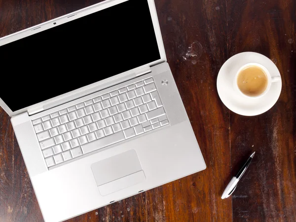 Современный ноутбук с чашкой кофе рядом — стоковое фото