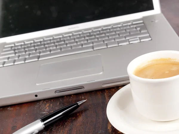 Laptop moderno com uma xícara de café ao lado dele — Fotografia de Stock