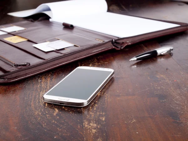 Old fashioned leather folder with blank paper and a modern smart — Stock Photo, Image