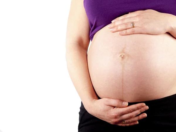 Pregnant young woman holding her naked belly — Stock Photo, Image