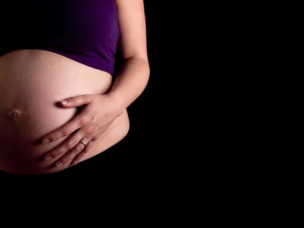 36 týdnů těhotná mladá žena drží její nahé břicho — Stock fotografie