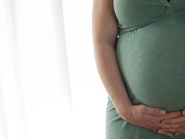 Pregnant young woman holding her belly — Stock Photo, Image