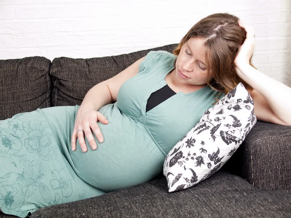 Zwangere jonge vrouw rusten op de Bank — Stockfoto