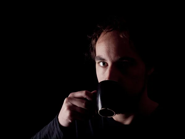 Low key image of a bearded man drinking coffee — Stock Photo, Image