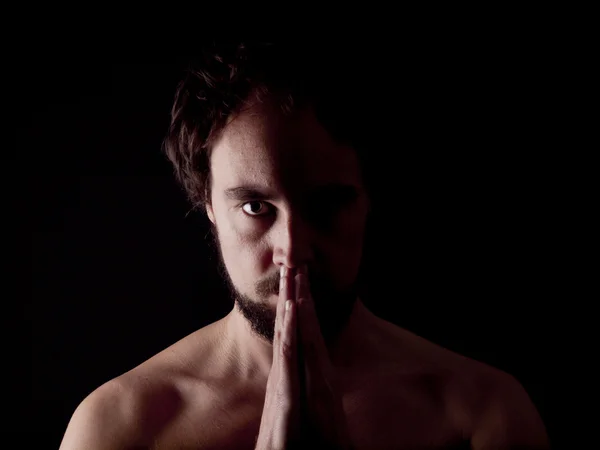 Low key image of a bearded man praying — Stock Photo, Image