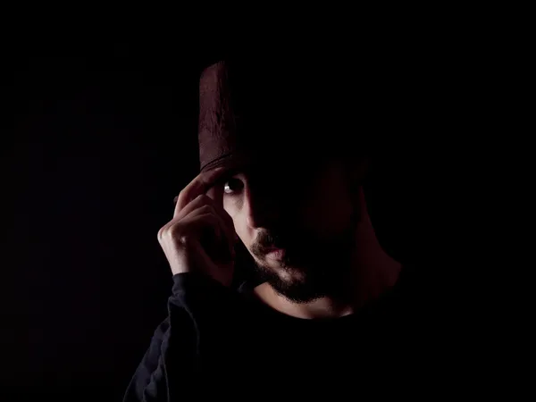 Low key image of a bearded man with a hat — Stock Photo, Image