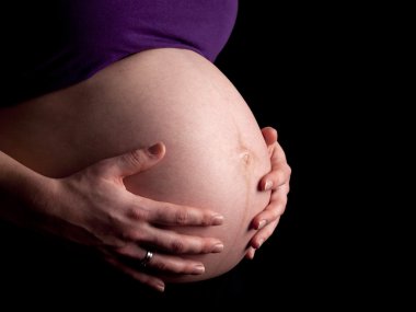 36 hafta hamile genç kadın çıplak karnına tutarak