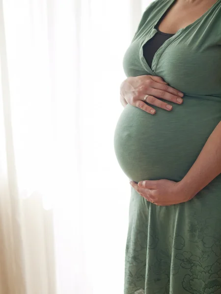 Mujer joven embarazada sosteniendo su vientre — Foto de Stock