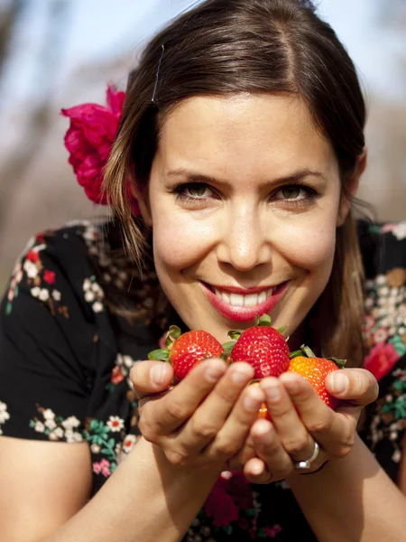 Mooi meisje ruiken verse aardbeien in het voorjaar — Stockfoto