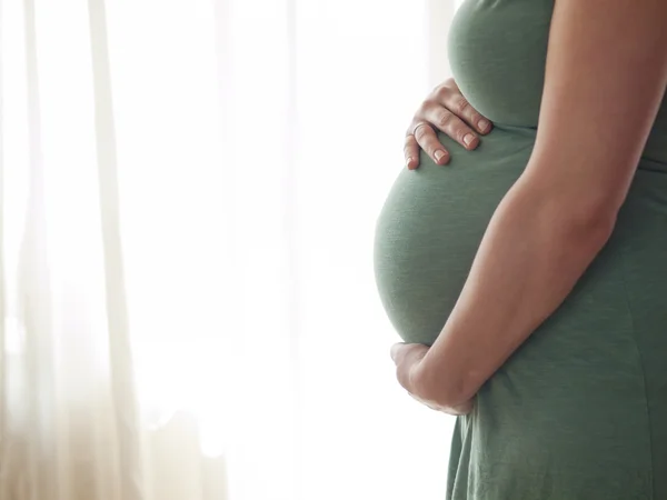 Jovem grávida segurando sua barriga — Fotografia de Stock