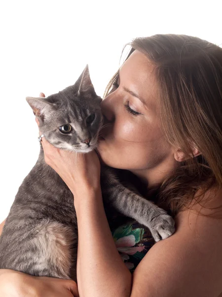 Smiling beautiful brunette kissing and petting her cute grey cat — Stock Photo, Image