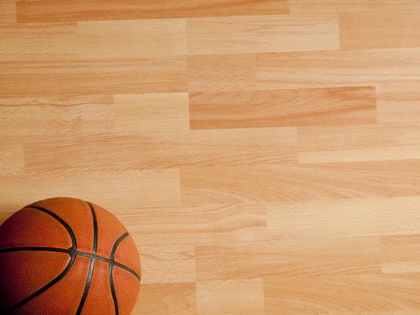 Una pelota naranja oficial en una cancha de baloncesto de madera dura Imágenes de stock libres de derechos