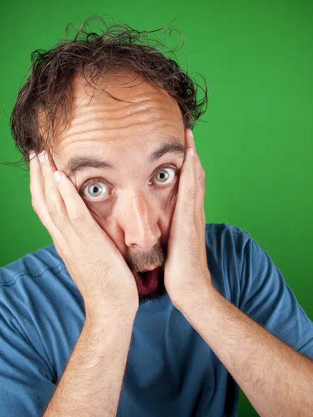 Thirty year old man holding his face in shock — Stock Photo, Image