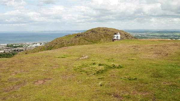 Mensen zitten op arthur's seat, edinburgh — Stockfoto