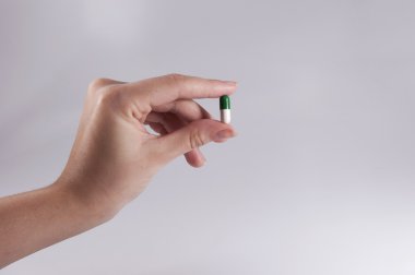 bir hap tutan beyaz zemin üzerine beyaz kadın