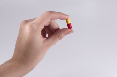 bir hap tutan beyaz zemin üzerine beyaz kadın