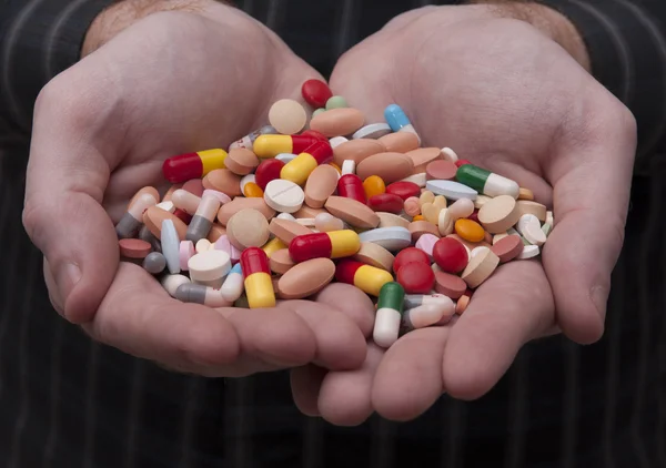 Caucasian Man Holding a Bunch of Pills and Capsules Stock Image