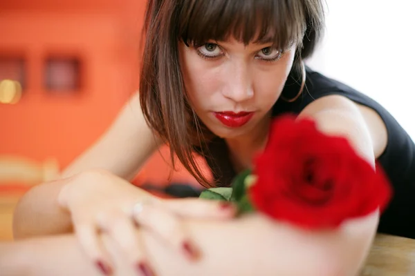 Mujer joven y solitaria con rosa roja, llorando — Foto de Stock