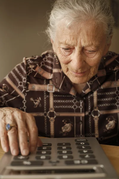 Donna anziana che utilizza calcolatrice — Foto Stock