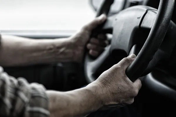 Worker hands on steering wheel — Stock Photo, Image