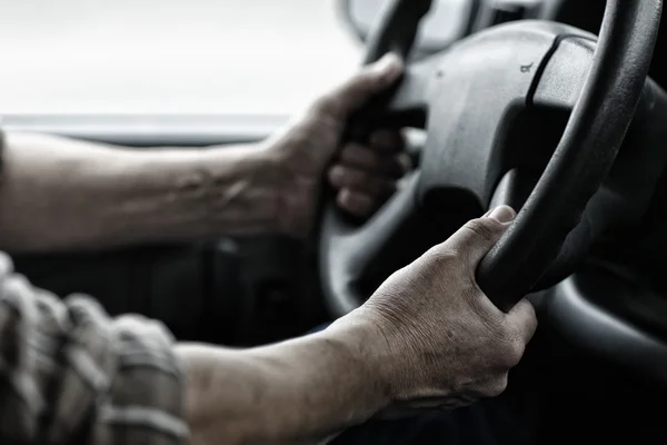 Manos de trabajo en el volante — Foto de Stock