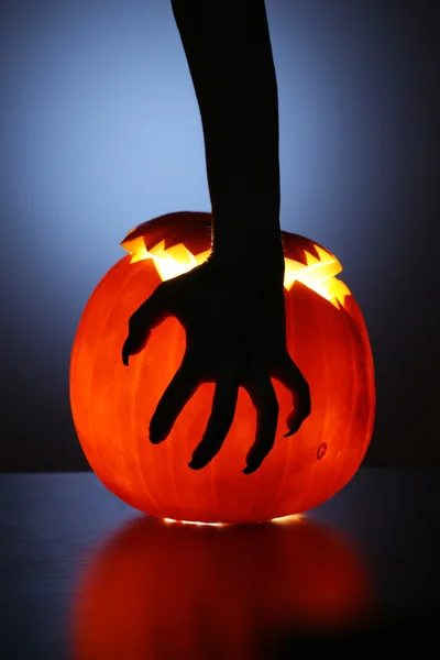Halloween pumpkin with witch hand over it — Stock Photo, Image