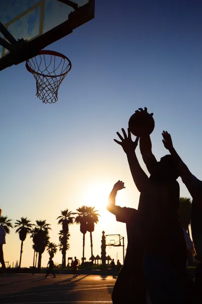 Basket spelare silhuetter i solnedgången — Stock fotografie